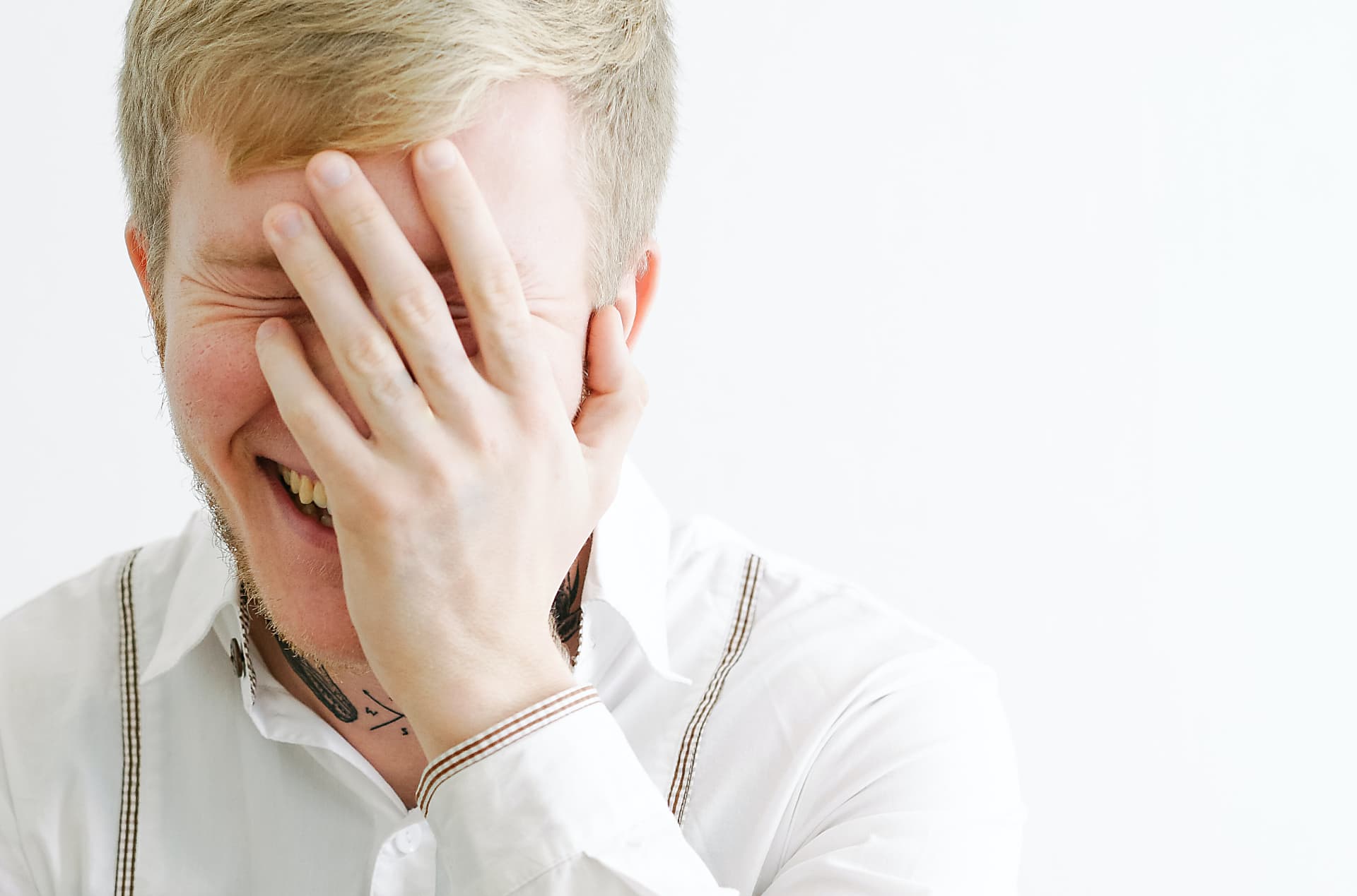 Junger Mann hält sich erleichtert und ungläubig lachend die Hand vor das Gesicht. Schuldenfrei mit Unterstützung der Schuldnerberatung Glinde
